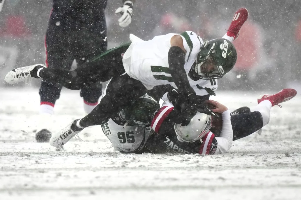 New York Jets linebacker Jermaine Johnson (11) and defensive tackle Quinnen Williams (95) sack New England Patriots quarterback Bailey Zappe (4) during the second half of an NFL football game, Sunday, Jan. 7, 2024, in Foxborough, Mass. (AP Photo/Steven Senne)