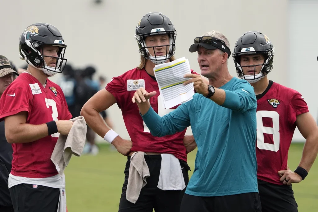 Jacksonville Jaguars quarterbacks coach Mike McCoy works with quarterbacks from left, C.J. Beathard, Trevor Lawrence and Nathan Rourke during NFL football training camp, Friday, July 28, 2023, in Jacksonville, Fla. (AP Photo/John Raoux)
