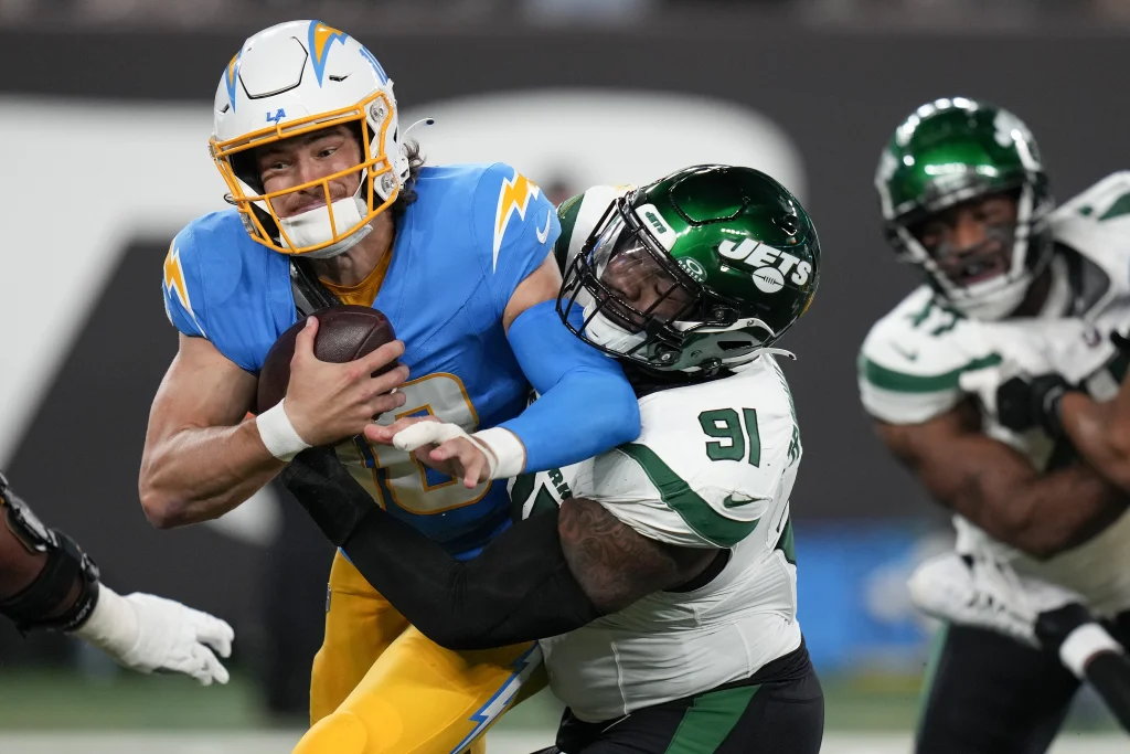 Los Angeles Chargers quarterback Justin Herbert (10) is tackled by New York Jets defensive end John Franklin-Myers (91) during the second quarter of an NFL football game, Monday, Nov. 6, 2023, in East Rutherford, N.J. (AP Photo/Seth Wenig)