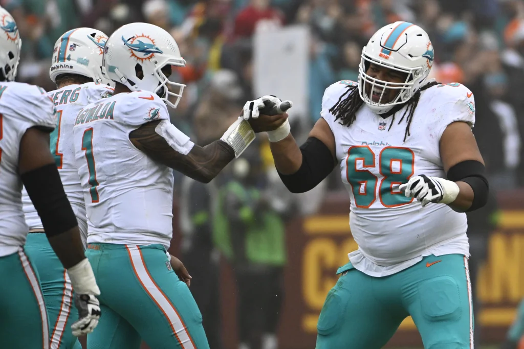 Dec 3, 2023; Landover, Maryland, USA; Miami Dolphins quarterback Tua Tagovailoa (1) celebrates with offensive tackle Robert Hunt (68) after a touchdown pass against the Washington Commanders during the first half at FedExField. Mandatory Credit: Brad Mills-USA TODAY Sports