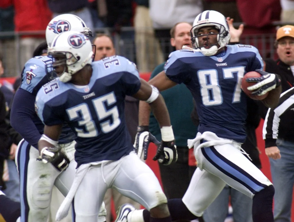 In this Jan. 8, 2000, file photo, Tennessee Titans wide receiver Kevin Dyson (87) looks back as he returns a kickoff in the fourth quarter during an AFC wild card football game in Nashville, Tenn. Blocking for Dyson are Perry Phenix (35) and Greg Favors (51). Dyson sped 75 yards down the left sideline with a lateral from Frank Wycheck on a kickoff for the winning touchdown with 3 seconds remaining, lifting the Tennessee Titans to a 22-16 playoff victory over the stunned Buffalo Bills. (AP Photo/Wade Payne, File)