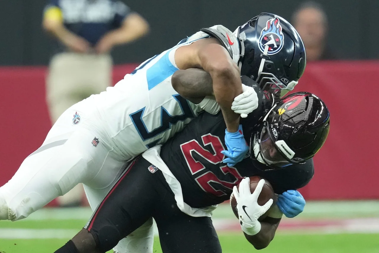  Tennessee Titans linebacker Cedric Gray, left, tackles Arizona Cardinals running back Michael Carter (22) during the second half of an NFL football game Sunday, Oct. 5, 2025, in Glendale, Ariz. (AP Photo/Ross D. Franklin)
