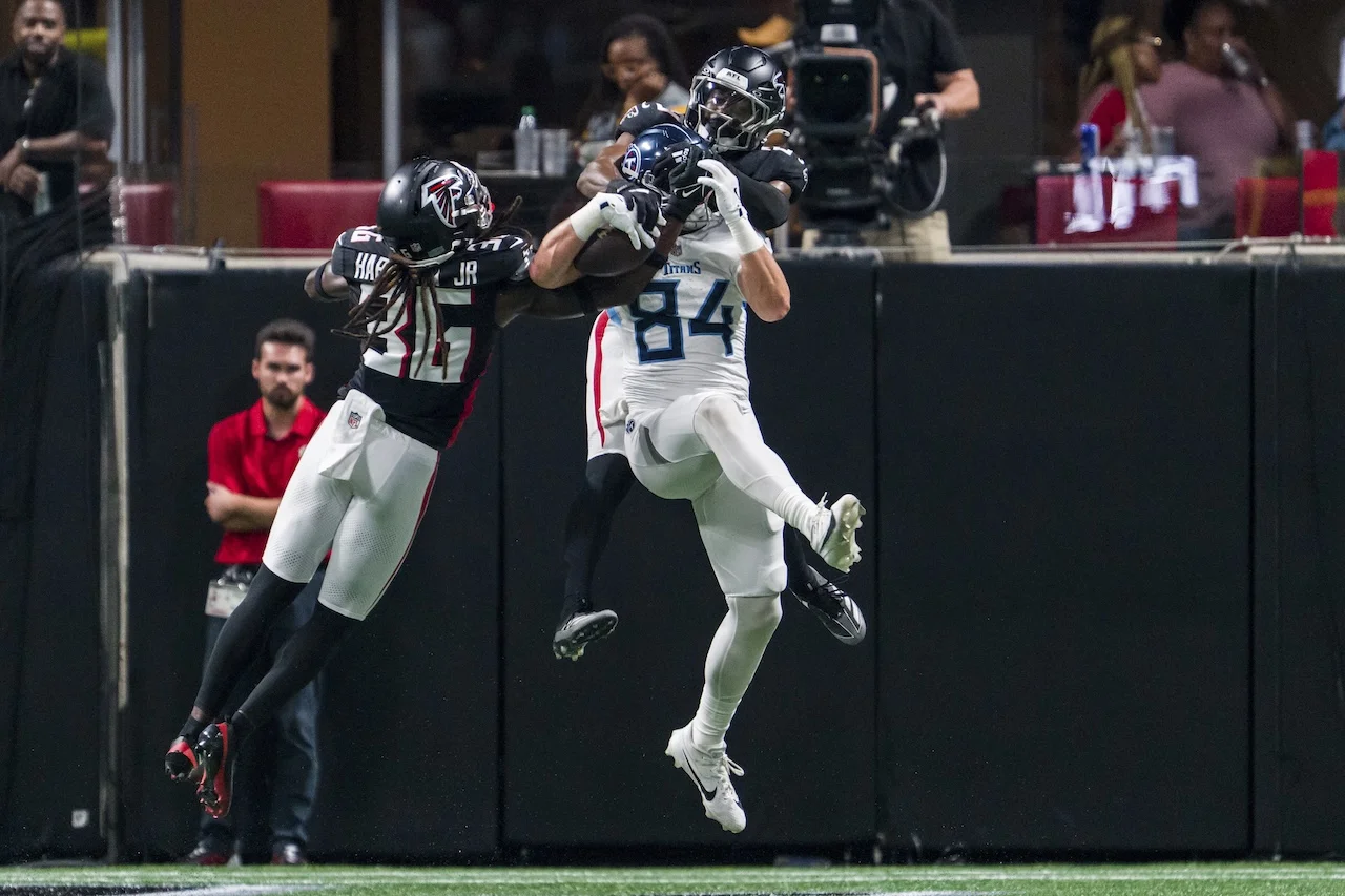 Tennessee Titans tight end Gunnar Helm (84) catches a pass for a touchdown as Atlanta Falcons safeties Jordan Fuller (29) and Ronnie Harrison Jr. (36) defend during the first half of an NFL preseason football game, Friday, Aug. 15, 2025, in Atlanta. (AP Photo/Danny Karnik)