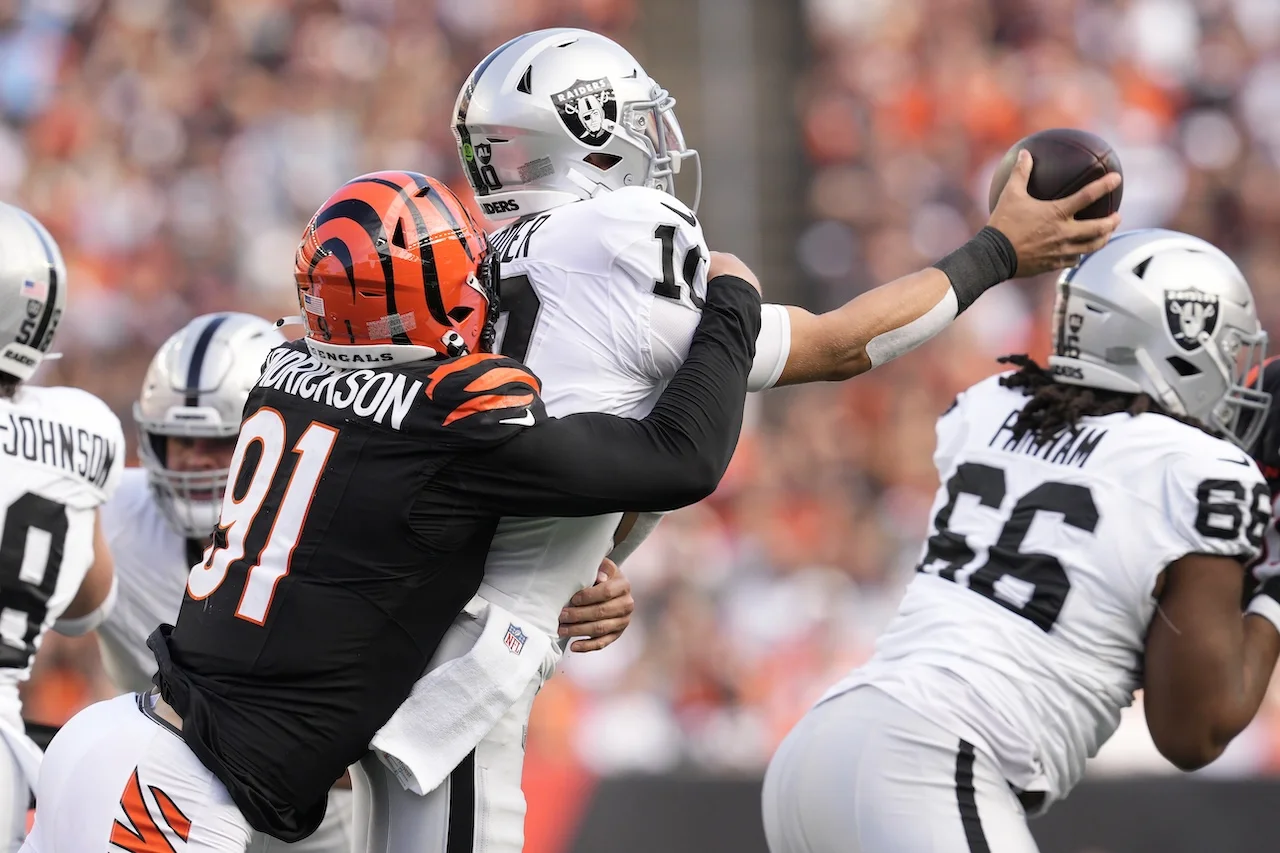 Cincinnati Bengals defensive end Trey Hendrickson, left, sacks Las Vegas Raiders quarterback Desmond Ridder during the second half of an NFL football game in Cincinnati, Sunday, Nov. 3, 2024. (AP Photo/Jeff Dean)