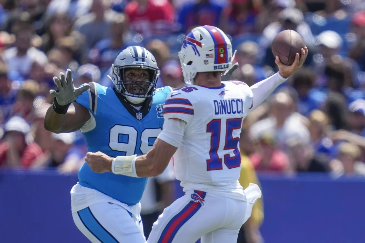 Carolina Panthers wide receiver Jonathan Mingo (15) passes under pressure from Carolina Panthers defensive tackle Shy Tuttle (99) in the first half of an NFL preseason football game, Saturday, Aug. 24, 2024, in Orchard Park, N.Y. (AP Photo/Charles Krupa)