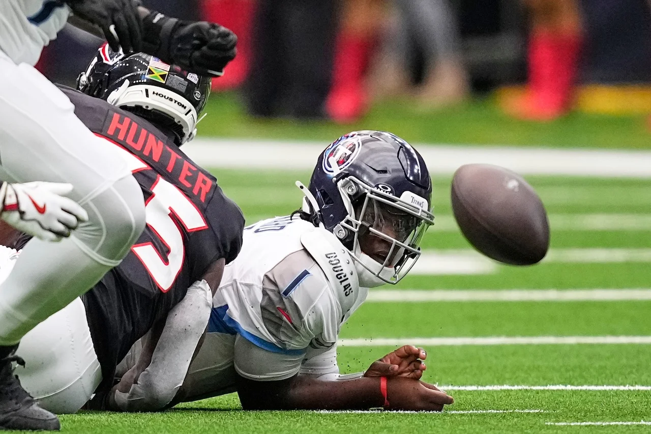 Tennessee Titans quarterback Cam Ward (1) loses the ball after being pressured by Houston Texans defensive end Danielle Hunter, left, during the first half of an NFL football game Sunday, Sept. 28, 2025, in Houston. (AP Photo/David J. Phillip)