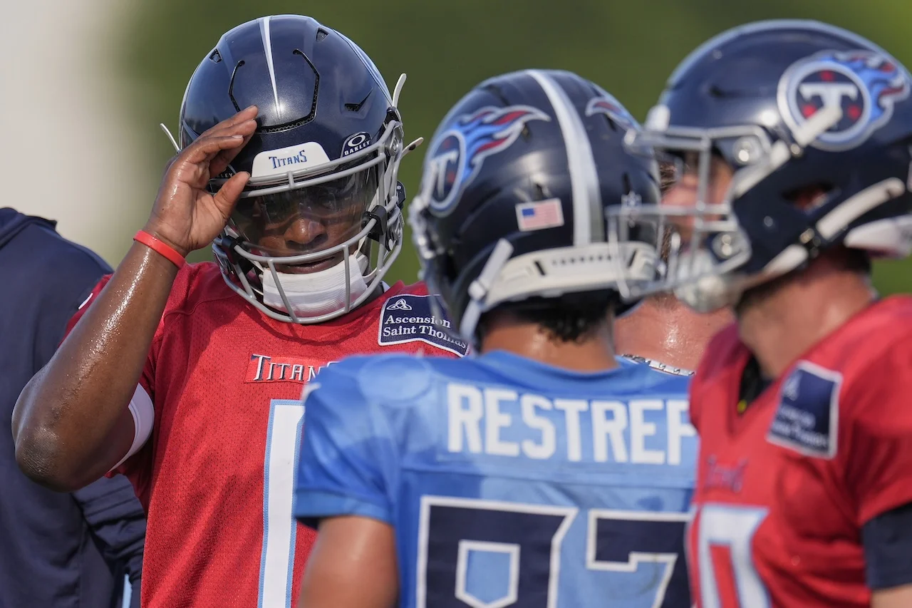 Tennessee Titans quarterback Cam Ward, left, salutes teammate wide receiver Xavier Restrepo, center, during practice at the team's NFL football training camp Wednesday, July 30, 2025, in Nashville, Tenn. (AP Photo/George Walker IV)