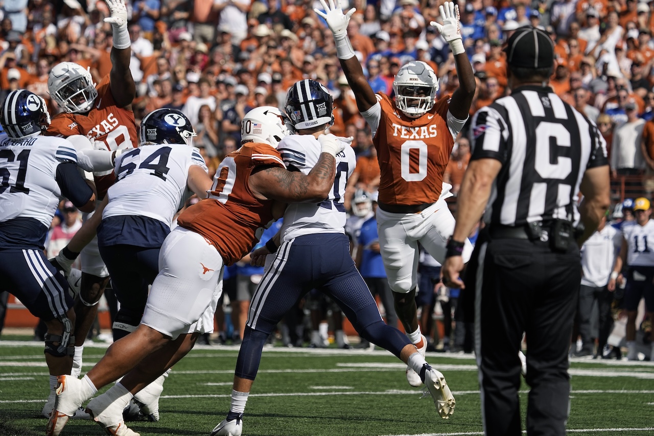 BYU quarterback Kedon Slovis (10) is pressured by Texas defensive lineman Byron Murphy II (90) and linebacker Anthony Hill Jr. (0) during the first half of an NCAA college football game in Austin, Texas, Saturday, Oct. 28, 2023. (AP Photo/Eric Gay)