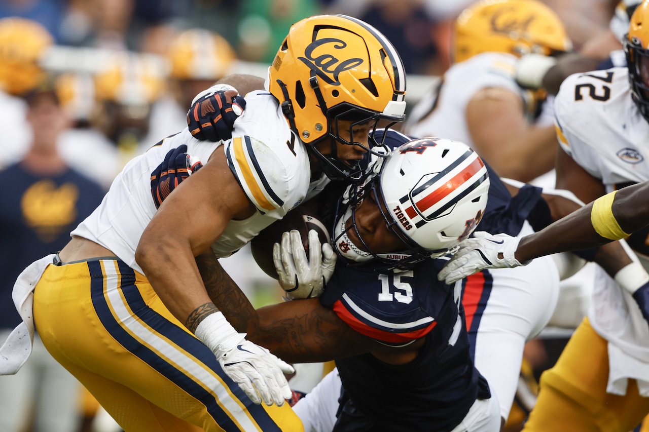 California running back Jaydn Ott (1) is stopped for a loss by Auburn defensive lineman Keldric Faulk (15) during the second half of an NCAA college football game, Saturday, Sept. 7, 2024, in Auburn, Ala. (AP Photo/Butch Dill)