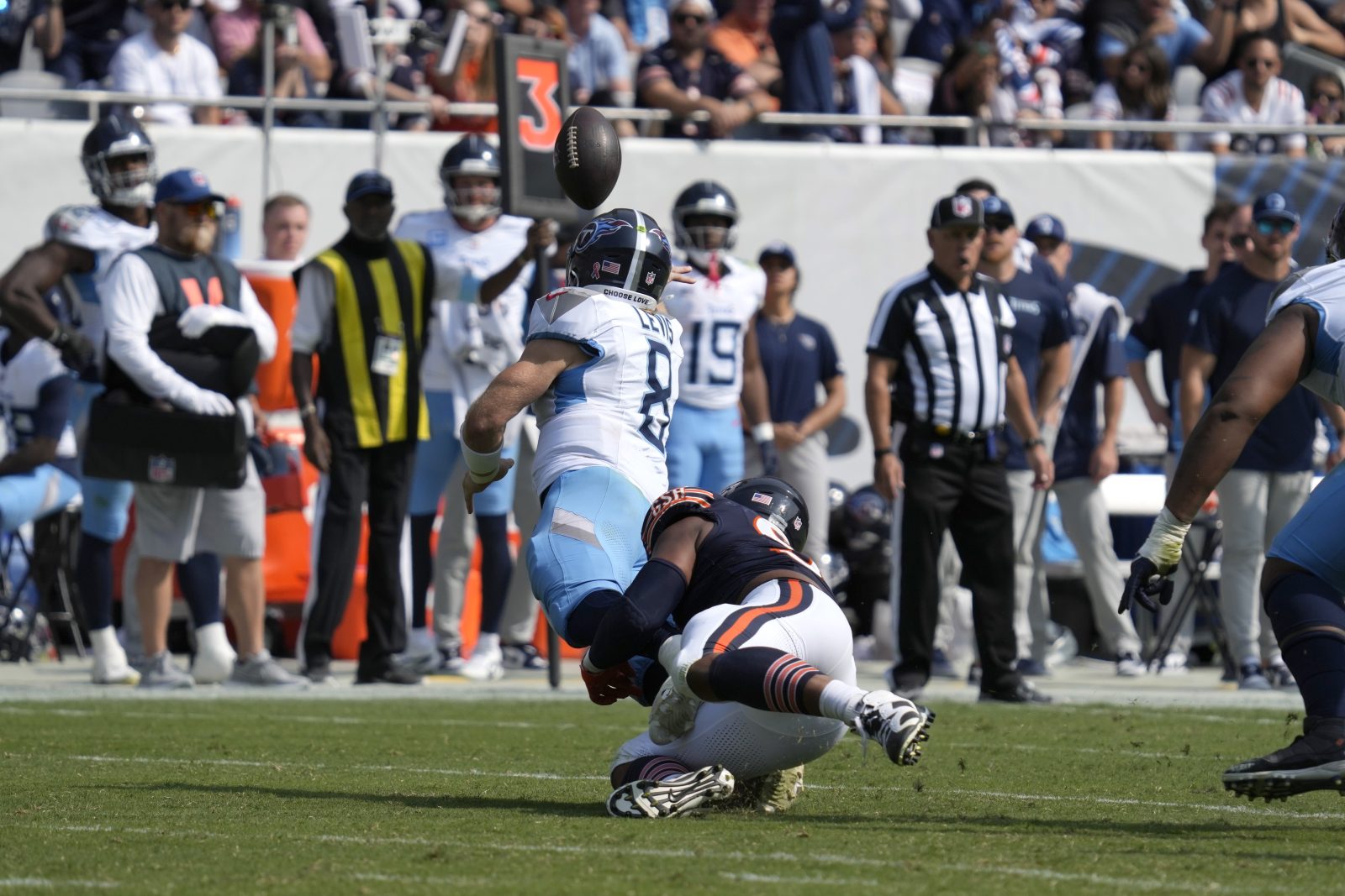 Tennessee Titans quarterback Will Levis throws an interception for a Bears' touchdown off pressure from defensive end DeMarcus Walker during the second half of an NFL football game Sunday, Sept. 8, 2024, in Chicago. (AP Photo/Nam Y. Huh)
