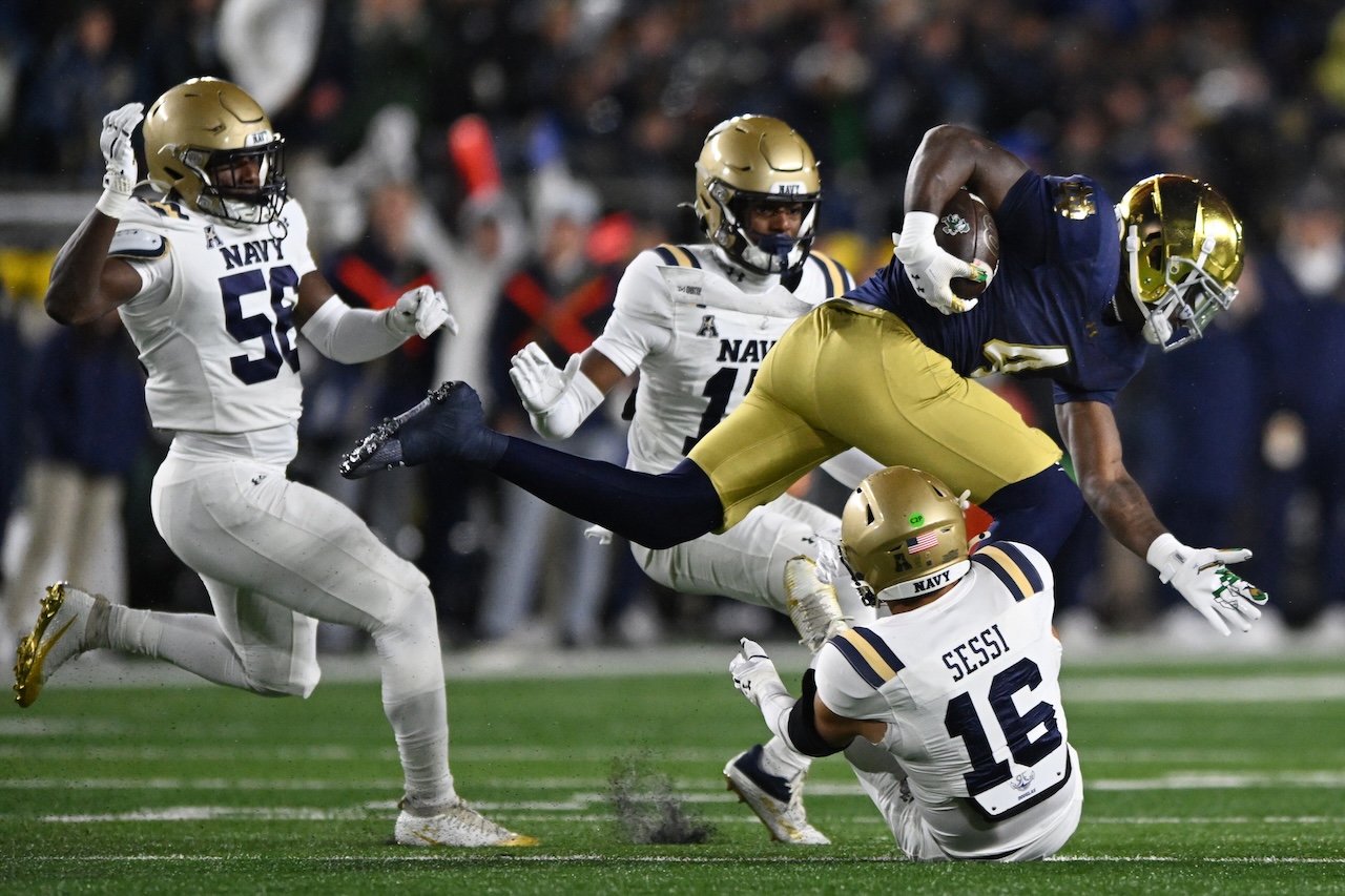 Notre Dame running back Jeremiyah Love (4) rushes against Navy's Giuseppe Sessi (16) during the first quarter of an NCAA football game, Saturday, Nov. 8, 2025, in South Bend, Ind. (AP Photo/Paul Beaty)