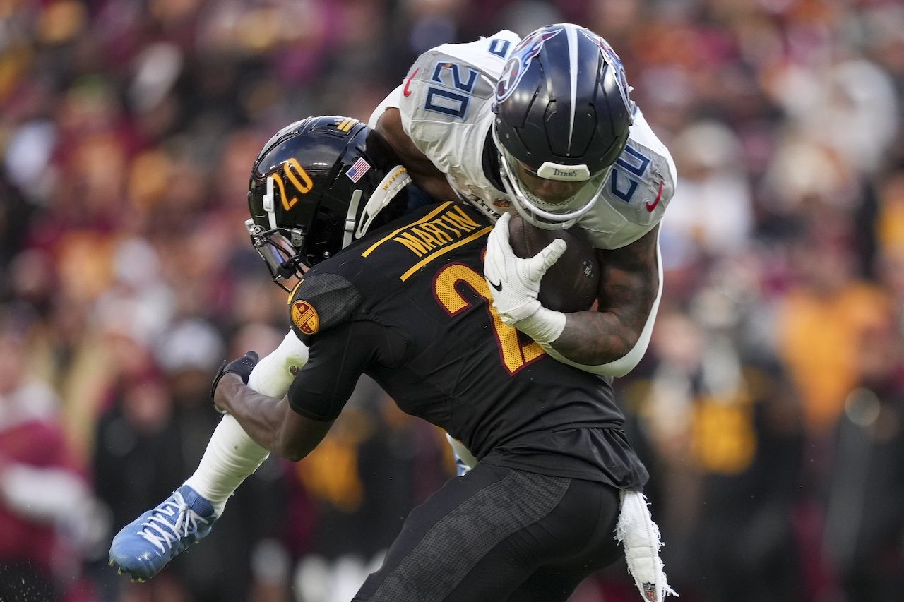 Tennessee Titans running back Tony Pollard, right, is tackled by Washington Commanders safety Quan Martin, left, after a catch during the second half of an NFL football game Sunday, Dec. 1, 2024, in Landover, Md. (AP Photo/Matt Slocum)