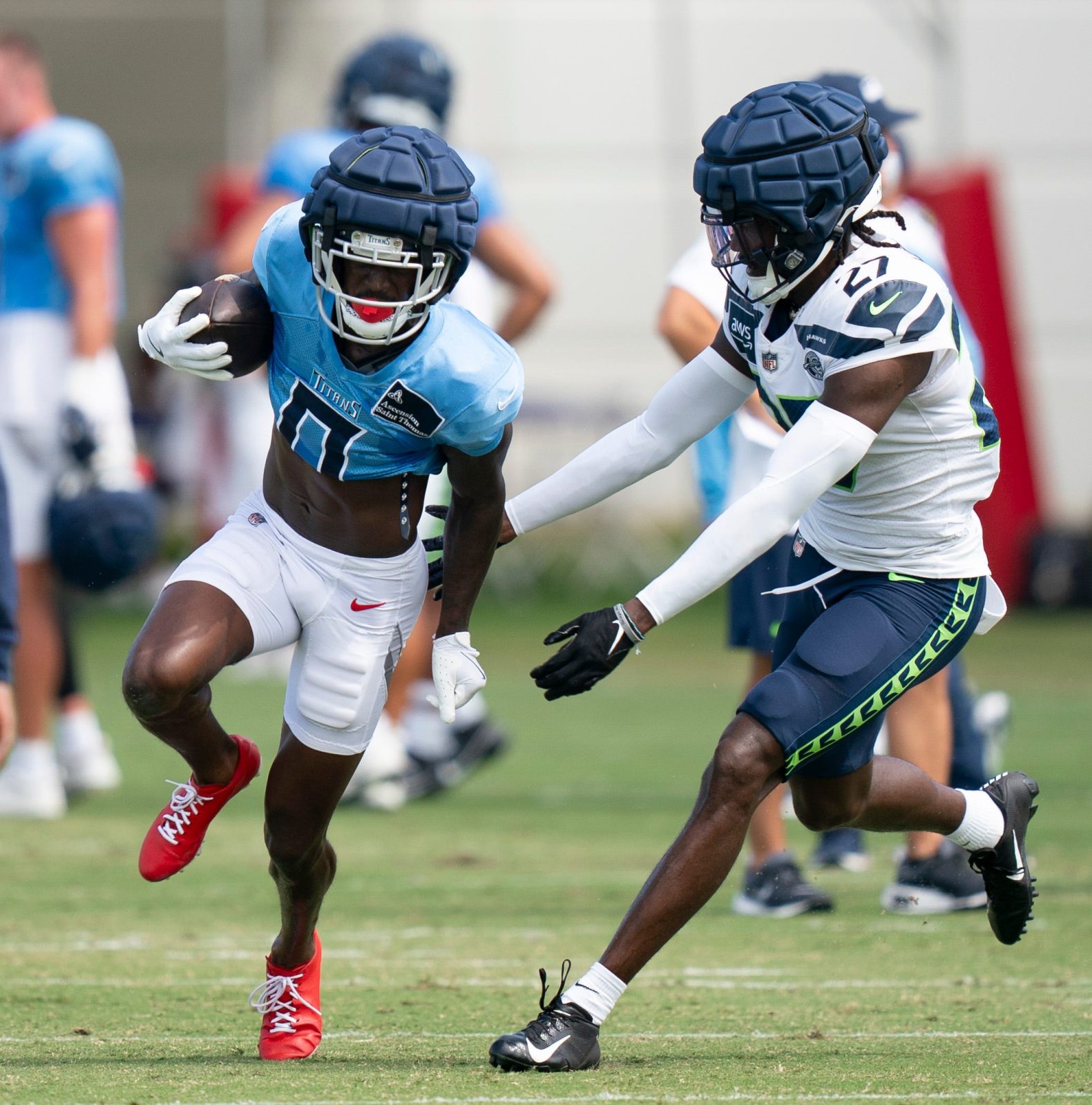 Tennessee Titans wide receiver Calvin Ridley (0) runs after a catch against Seattle Seahawks cornerback Riq Woolen (27) at Ascension Saint Thomas Sports Park in Nashville, Tenn., Wednesday, Aug. 14 2024. This is the first day of the Titans joint practice with the Seattle Seahawks.