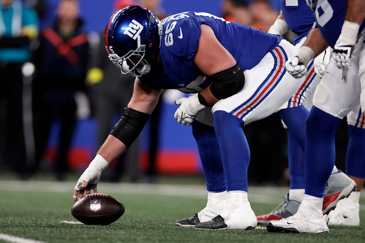 New York Giants guard Austin Schlottmann (65) grabs the ball at the line of scrimmage during the second half of an NFL football game against the Philadelphia Eagles, Thursday, Oct. 9, 2025, in East Rutherford, N.J. (AP Photo/Adam Hunger)