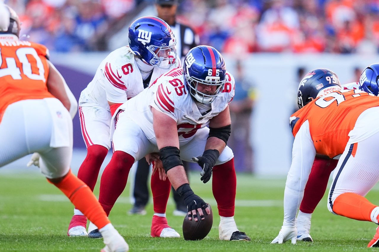 New York Giants guard Austin Schlottmann (65) snaps the ball to quarterback Jaxson Dart (6) against the Denver Broncos during an NFL football game Sunday, Oct. 19, 2025, in Denver. (AP Photo/Jack Dempsey)