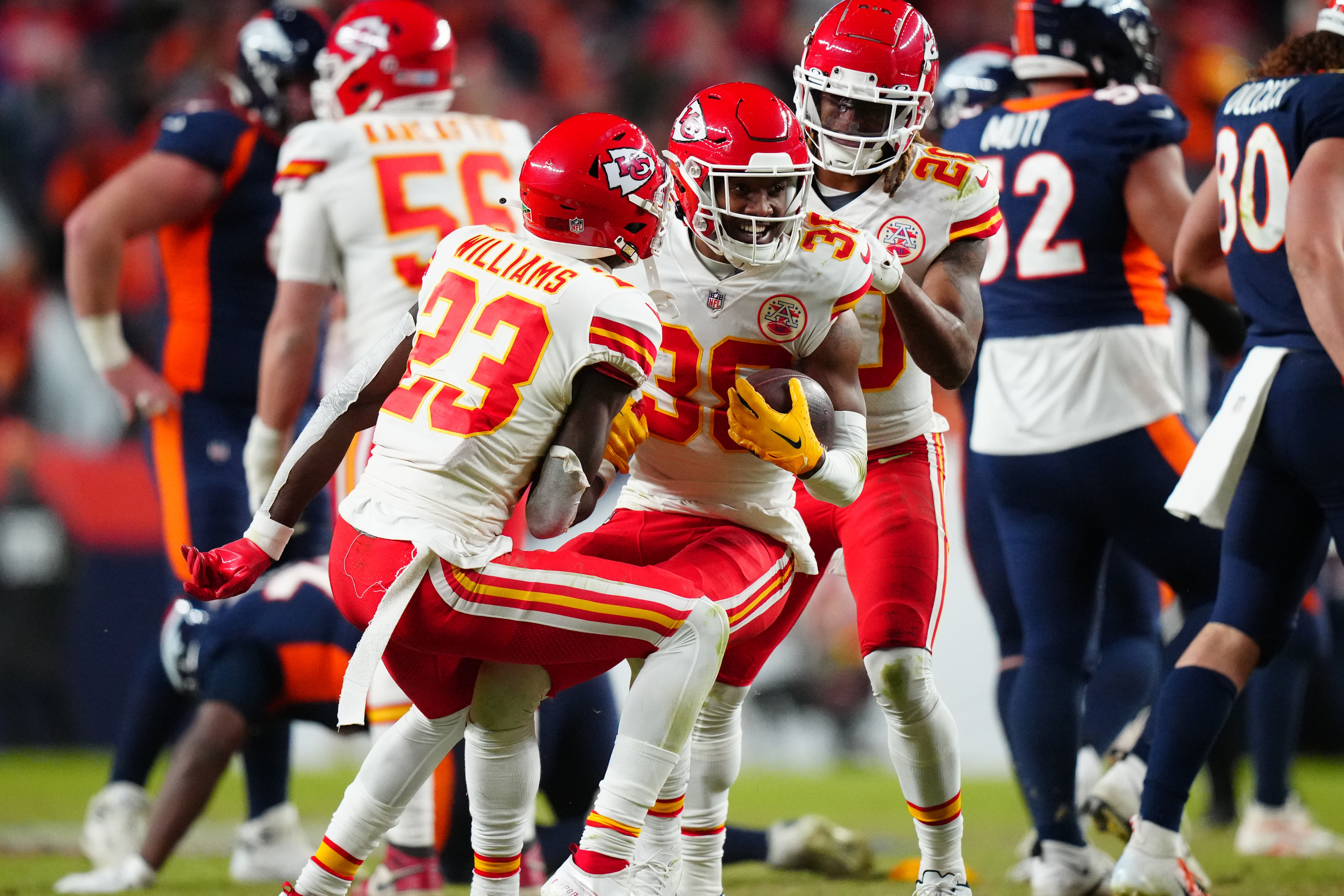 Dec 11, 2022; Denver, Colorado, USA; Kansas City Chiefs cornerback L'Jarius Sneed (38) celebrates his interception with cornerback Joshua Williams (23) and safety Justin Reid (20) n the fourth quarter against the Denver Broncos at Empower Field at Mile High. Mandatory Credit: Ron Chenoy-USA TODAY Sports