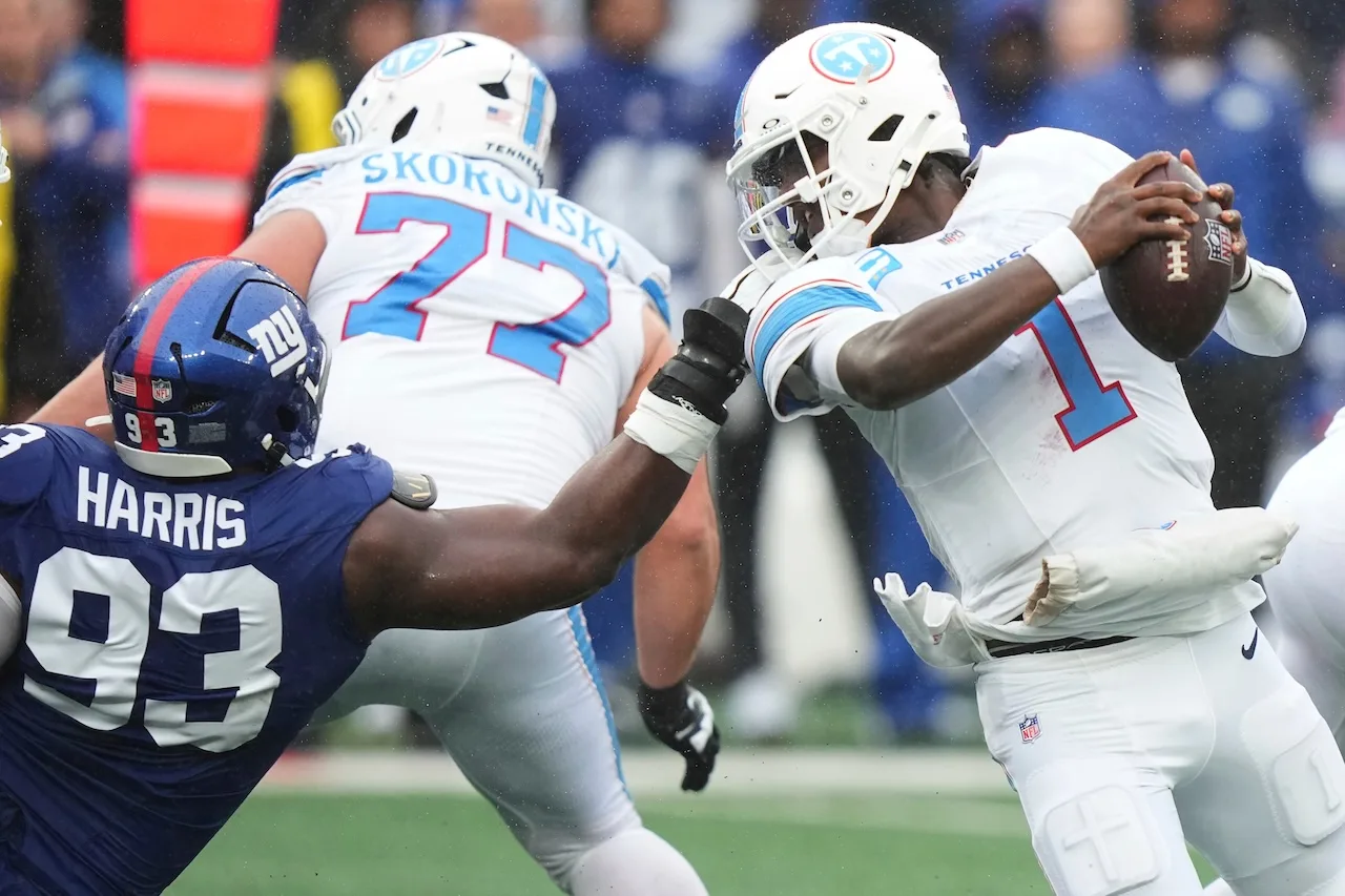 New York Giants defensive tackle Shelby Harris (93) grabs the facemask of Tennessee Titans quarterback Cam Ward (1) during the second half of an NFL football game in East Rutherford, N.J., Sunday, Sept. 27, 2026. (AP Photo/Frank Franklin II)