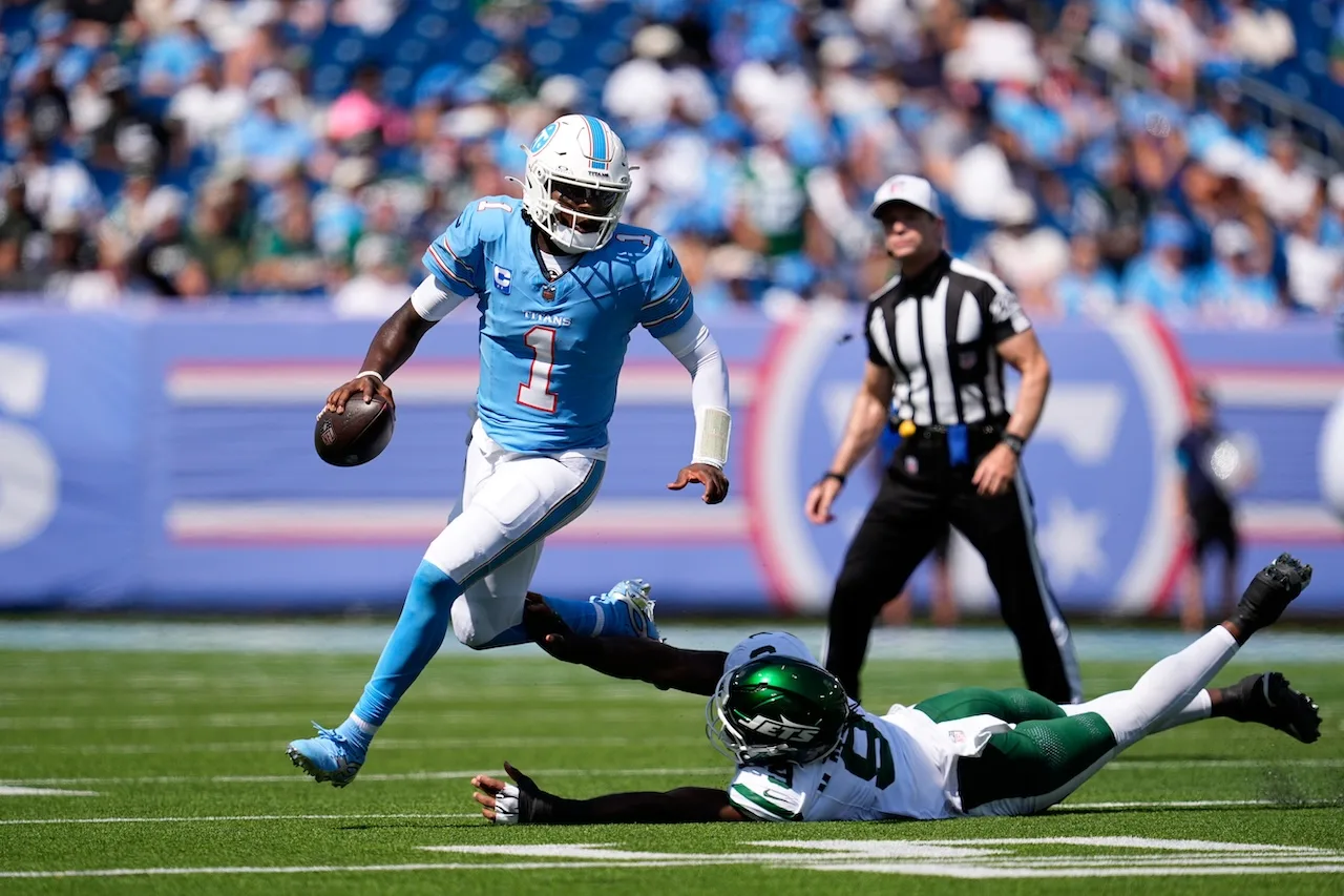 Tennessee Titans quarterback Cam Ward (1) scrambles past New York Jets defensive end Will McDonald IV (9) during the second half of an NFL football game, Sunday, Sept. 13, 2026, in Nashville, Tenn. (AP Photo/George Walker IV)